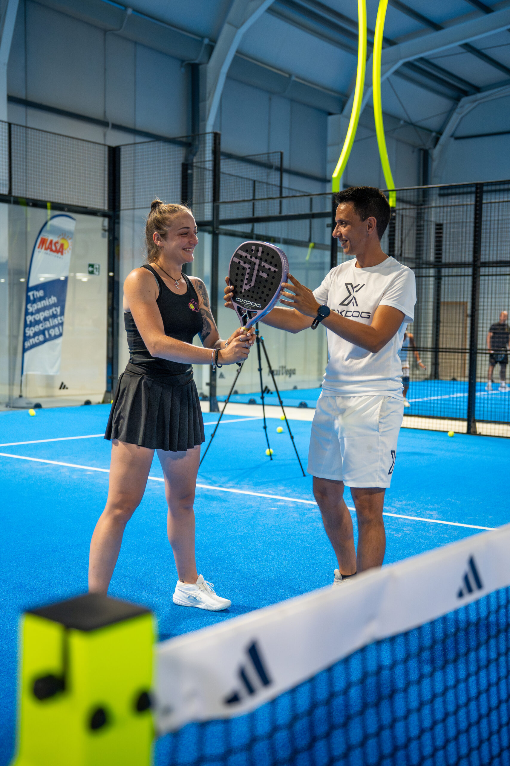 Home Entrenador y jugadora en una pista de pádel